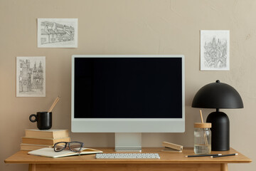 Aesthetic composition of simple office interior with wooden desk, computer, books, black sculpture, cup with pencils, brown wall and personal accessories. Home decor. Template.