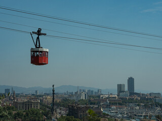 red cable car over barcelona, ​​view of the city from above © Jus