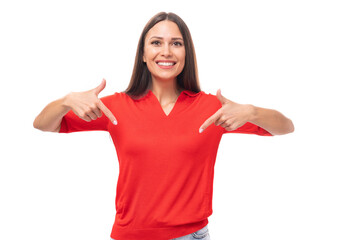young cute caucasian brunette in a red short-sleeved shirt points with index fingers at the space for advertising