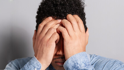 man covering his face with hands