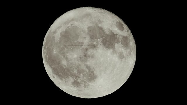 Plane flying in front of the moon