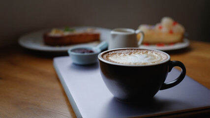 A cup of cappuccino coffee with soft foam on a wooden table. The coffee moment concept is everywhere.