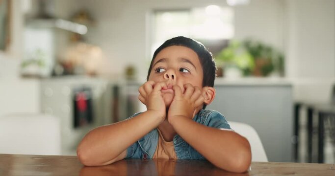 Bored, thinking and a child at a table in a house for naughty behavior, grounded or in time out. Idea, home and a little boy or kid at a dining room desk with adhd, sad or a problem from a mistake