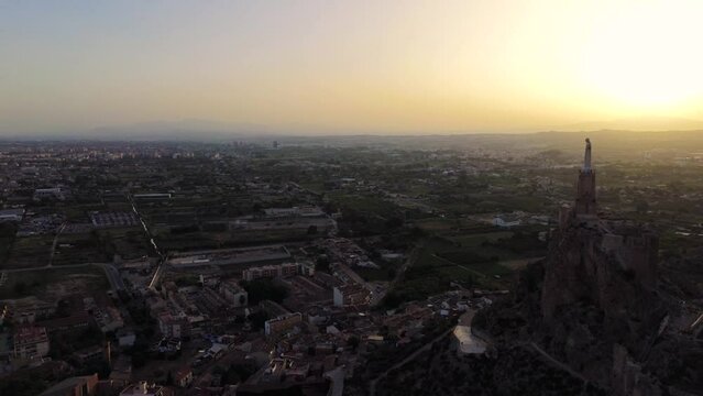 Cityscape of Murcia with Christ of Monteagudo statue at sunset