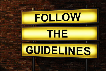 Follow the guidelines. Black letters on a yellow illumintaed light box, red brick wall. Rules, manual, advice, authority, strategy, management, instruction, procedure. 3D illustration