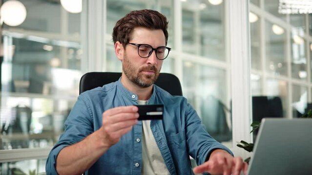 Happy businessman client businessman use banking mobile phone app at office hold plastic credit card enter secure code buy goods in internet store shopping online cryptocurrency money transaction.