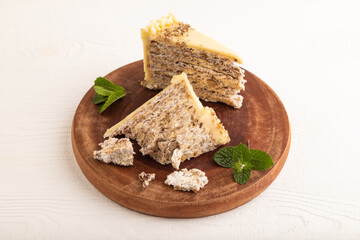 Walnut and almond cake on white wooden, side view.