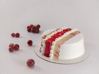 Delicious grape fruit cake on white surface