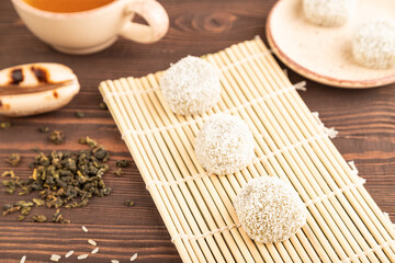 Japanese rice sweet buns mochi filled with pandan and coconut jam on brown wooden, side view, selective focus