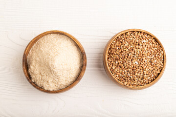 Powdered milk and buckwheat baby food mix, on white wooden, top view