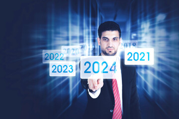 Male businessman pressing 2024 new year button