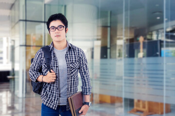 Obraz premium Photo of serious young male student standing in front of glass door