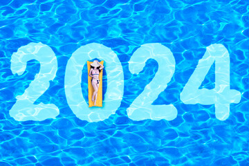 woman in bikini lying on the inflatable float with 2024 number in the swimming pool