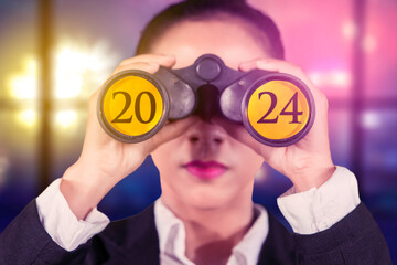 Female entrepreneur using binoculars with the 2024 new year numbers - Powered by Adobe