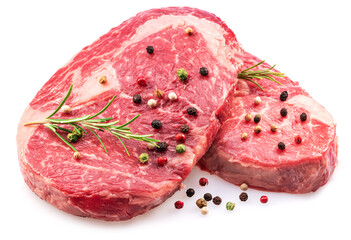 Raw ribeye steaks with peppercorn and rosemary isolated on white background. Closeup.