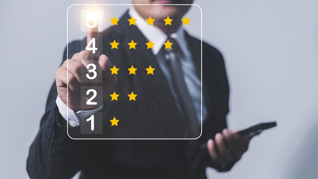 close up on customer man hand pressing on smartphone screen with gold five star rating feedback icon and press level excellent rank for giving best score point to review the service , business concept - Powered by Adobe