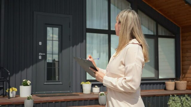Woman realtor reviewing house description provided by property management company. Female estate agent reading specifications of new house