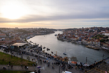 Panorámica de un atardecer en la ciudad portuguesa de Oporto con el sol escondiéndose por detrás del río Duero. - obrazy, fototapety, plakaty