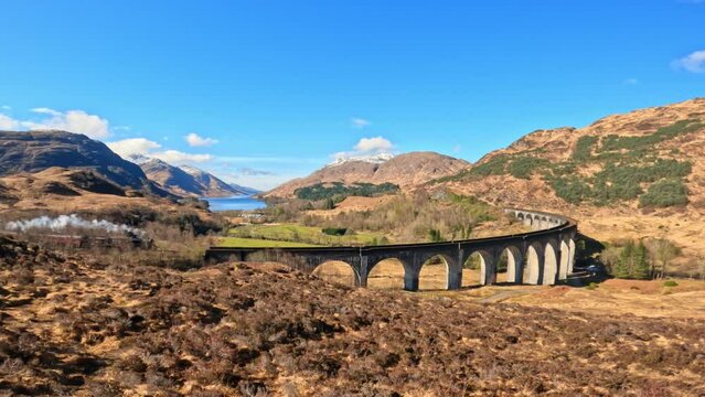 Iconic Jacobite Steam train crossing Glenfinnan viaduct in Scotland