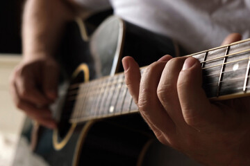 Playing the guitar. Strumming acoustic guitar. Musician plays music. Man fingers holding mediator....