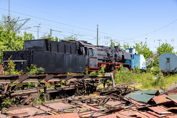 Lost place with old, rusted, historic steam train in the sunlight in Germany