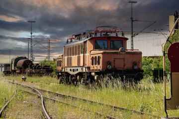 Obraz premium Lost place with old rusted electric train with stormy sky