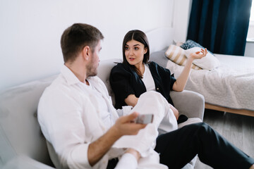 Confident couple arguing with each other on sofa