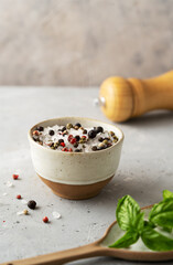 Sea salt with spices in small ceramic bowl, salt ginger and spoon with basil on concrete background. Copy space for text