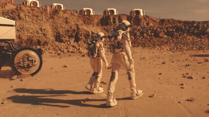 Two astronauts in spacesuits walk toward research station, colony or scientific base on Mars. AI...