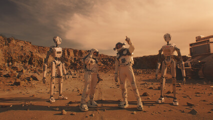 Two astronauts in spacesuits talk, stand on Mars surface with robots. AI powered rover in the...