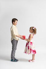 The older boy congratulates and gives the younger girl a holiday gift.
