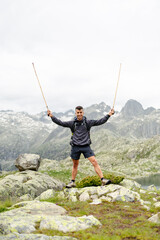 Obraz premium Young man standing on a rock with mountain background
