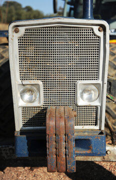 Front of an old tractor with iron counterweights. Vehicle for agricultural work frontal view
