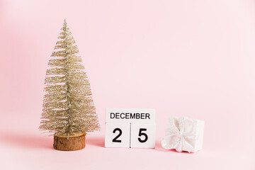 Christmas decoration and calendar with date December 25 on pink paper background with copy space. Christmas and New Year celebration concept.