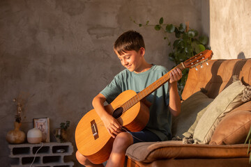 Preteen child, boy, learning how to play acoustic guitar at home