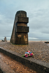 Fotografía en vertical de las flores junto al monumento por el Desembarco de Normandía en Omaha...