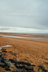 Fotografía de la playa del Desembarco de Normandía (Día D), Francia, con el cielo nublado.