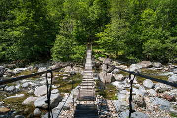 An old bridge over a river in National Park Val Grande. - obrazy, fototapety, plakaty
