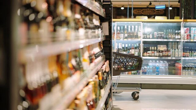 Man and woman walk around supermarket with shopping cart
