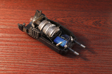 Image of an opened flashlight with old round batteries covered with oxides.