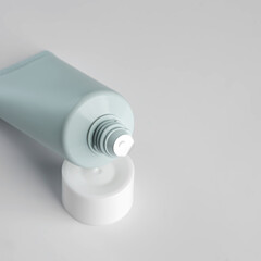 close up of open plastic aqueeze tube with cream, toothpaste, lotion or medicine on white background. New package before use. Cosmetics mockup