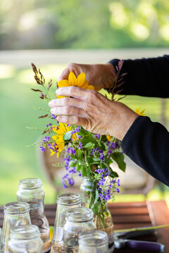 Person making flower arrangement for wedding with sunflower and geisha girl flower (Duranta erecta)