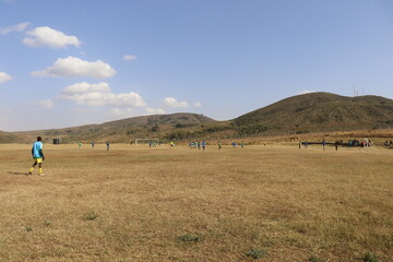 AIC TTI and Kamere Hotstars engage in a football match in the mountains. 