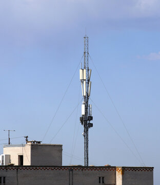 An image of a tower on the roof of a building with cellular antennas installed.