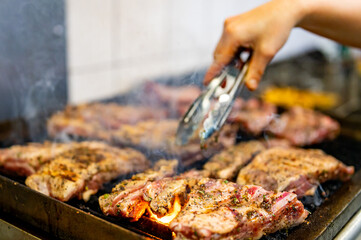 chef cooking pork ribs on grill in kitchen