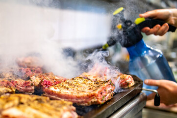 chef cooking pork ribs on grill in kitchen