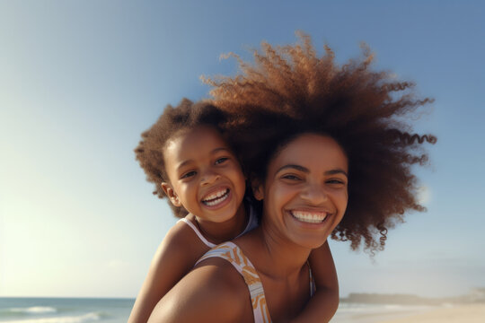 Smiling black mother and daughter having fun on the beach, sister giving piggyback ride, embracing mom. Copy space available.