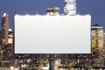 Blank white billboard on city buildings background at night, front view. Mockup, advertising concept