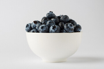 bowl with blueberries on a white background, close, horizontal, macro.