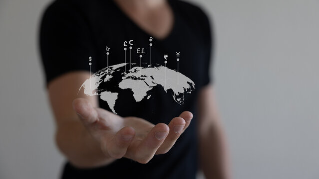 Global currency exchange concept, Hand holding world with virtual line effect and dollar yuan yen euro and pound sterling sign.